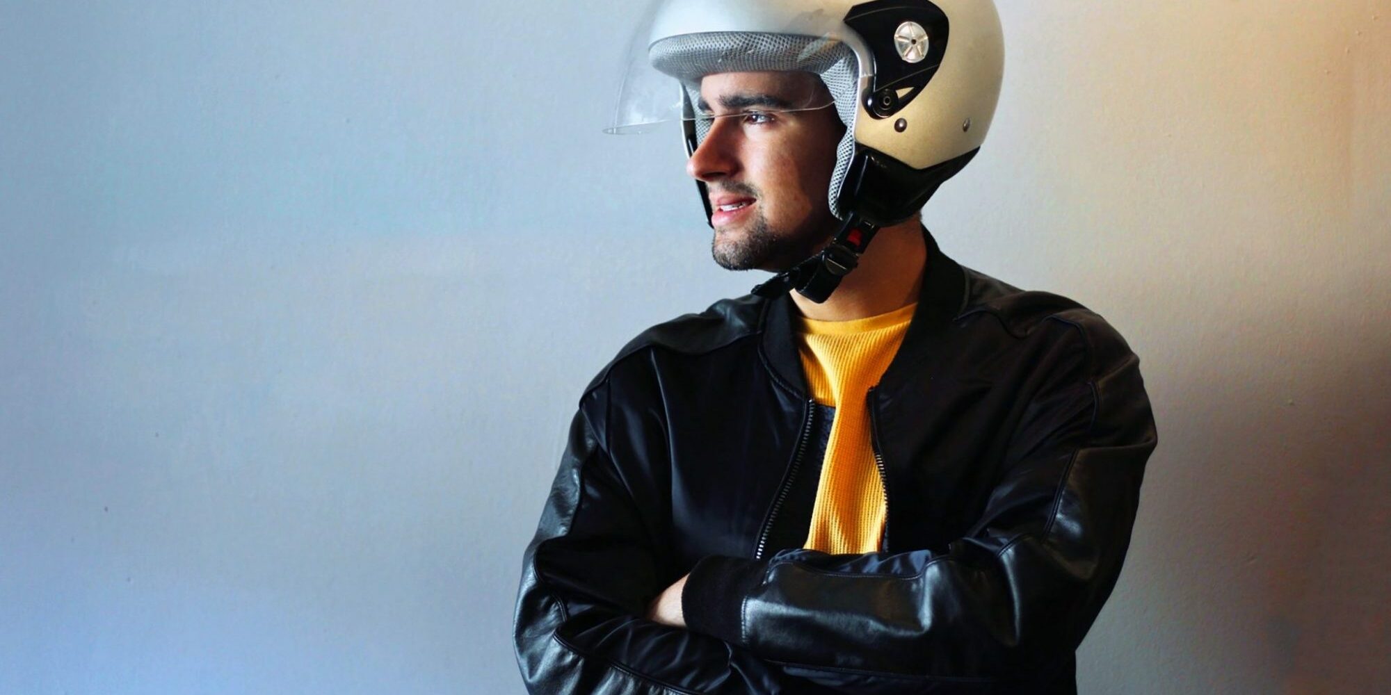 Young biker with a gray motorcycle helmet on. Road safety campaign. Copy Space.